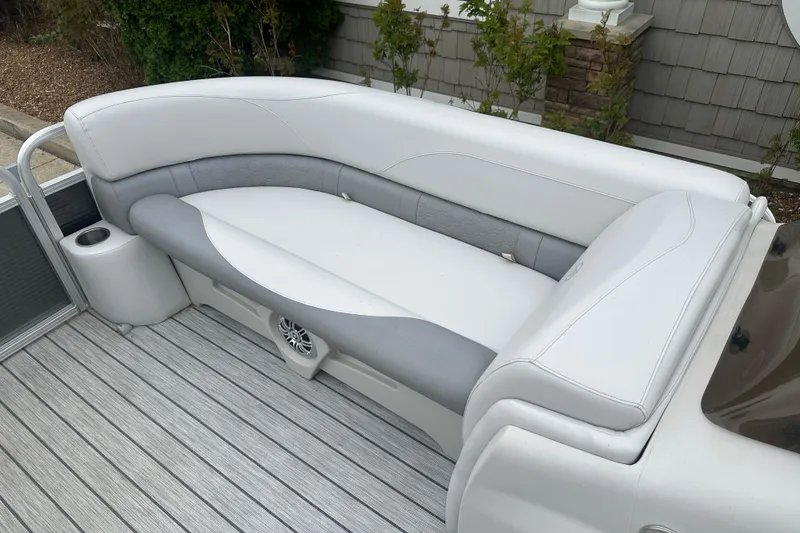 Slide: The Image of 2018 Avalon GS2185 boat seating with gray and white upholstery, featuring a cup holder and speaker. - 6