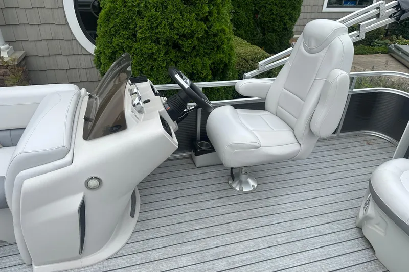 Slide: The Image of 2018 Avalon GS2185 boat interior with white captain's chair and steering console. - 7