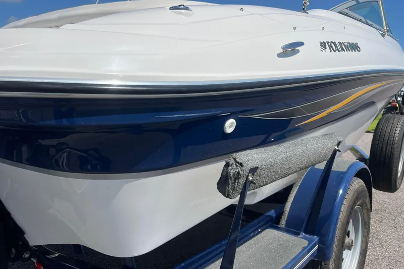 Slide: The Image of 2008 Four Winns H190 boat on trailer, featuring sleek blue and white design. - 12