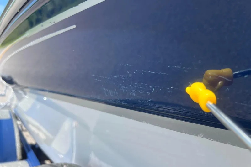 Slide: The Image of 2008 Four Winns H190 boat with visible hull scratches and repair tool. - 20