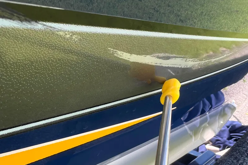 Slide: The Image of 2008 Four Winns H190 boat hull being cleaned with a yellow tool. - 31