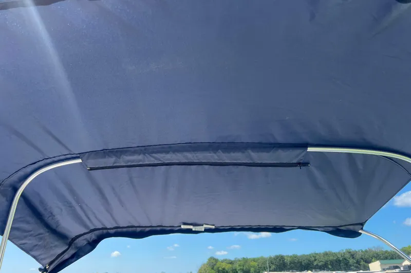 Slide: The Image of Bimini top of 2008 Four Winns H190 boat under clear blue sky. - 58