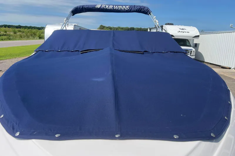 Slide: The Image of 2008 Four Winns H190 boat with blue cover, parked outdoors. - 8