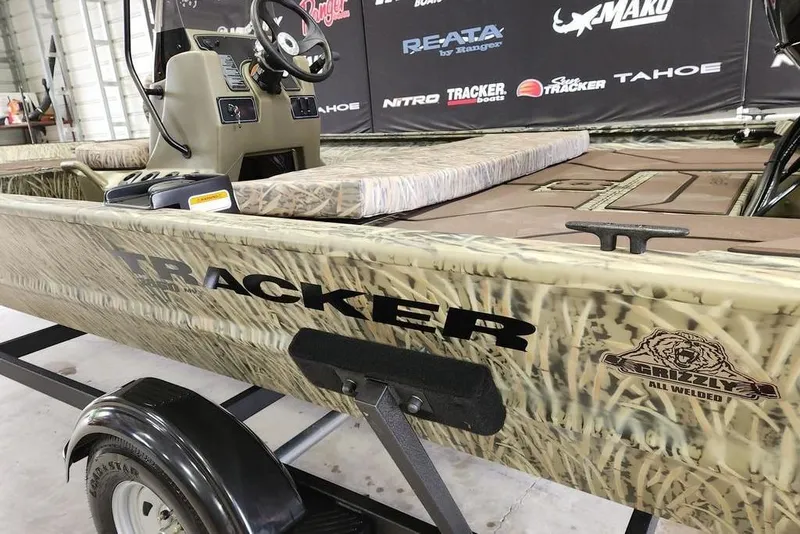 Slide: The Image of 2026 Tracker GRIZZLY® 1860 CC boat with camouflage design on a trailer. - 10