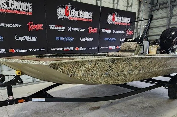 Slide: The Image of 2026 Tracker GRIZZLY® 1860 CC boat with camouflage design on display in a showroom. - 13
