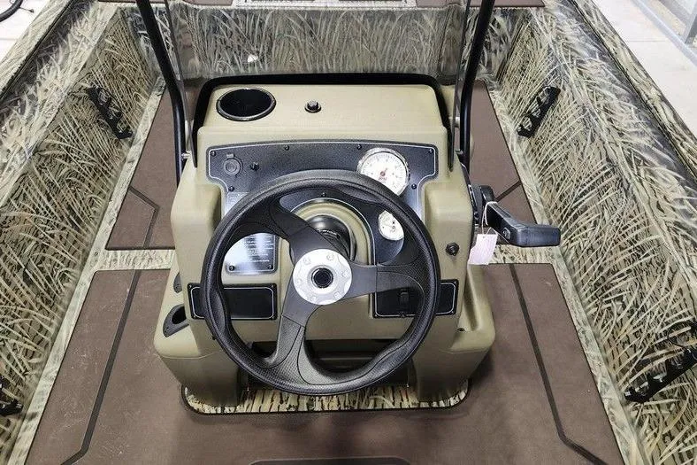 Slide: The Image of 2026 Tracker GRIZZLY® 1860 CC boat console with camo design and steering wheel. - 4