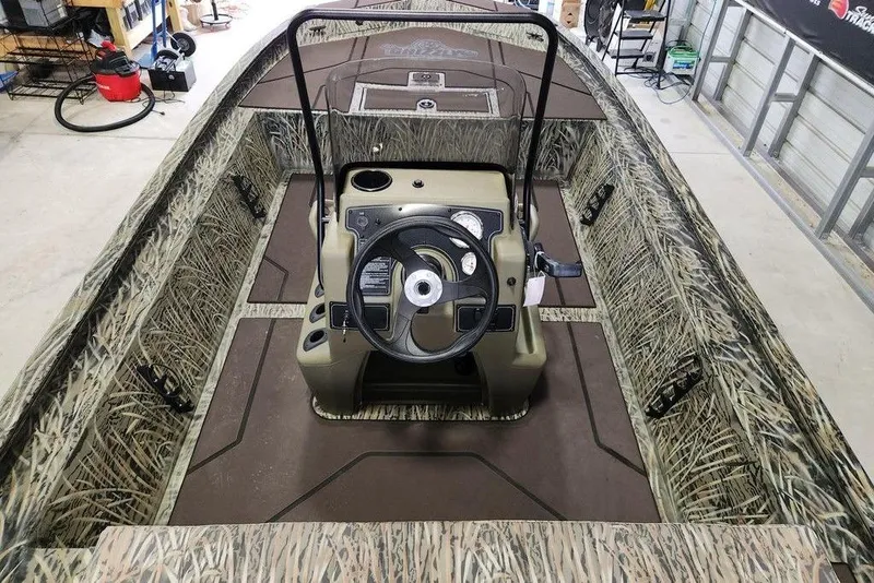 Slide: The Image of 2026 Tracker GRIZZLY® 1860 CC boat interior with camo design and central steering console. - 5