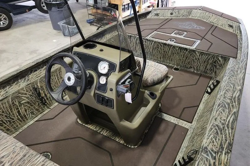 Slide: The Image of 2026 Tracker GRIZZLY® 1860 CC boat interior with camouflage design and steering console. - 7