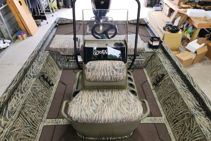 Slide: The Image of 2026 Tracker GRIZZLY® 1860 CC boat interior with camouflage seating and steering console. - 8