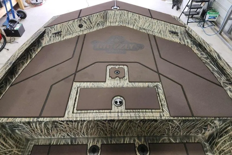 Slide: The Image of 2026 Tracker GRIZZLY® 1860 CC boat deck with camo pattern and storage compartments. - 9