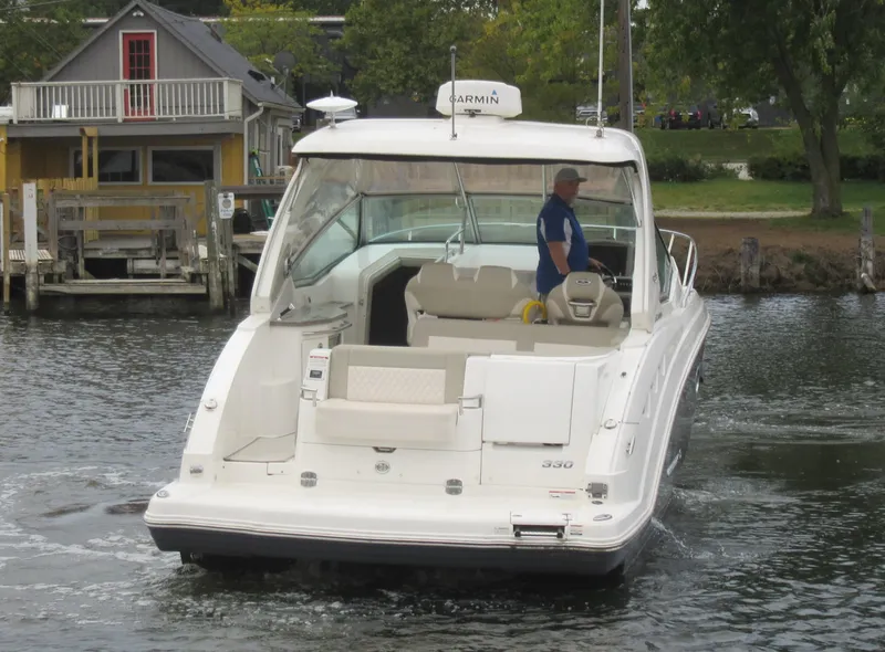 Slide: The Image of 2017 Chaparral 330 Signature boat on calm water under clear blue sky. - 2