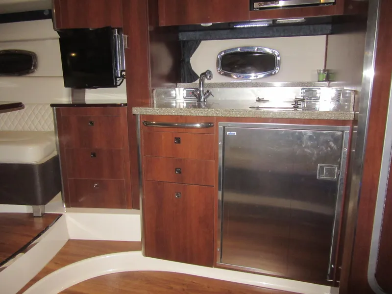 Slide: The Image of 2017 Chaparral 330 Signature cabin interior with wood finish and seating area. - 24