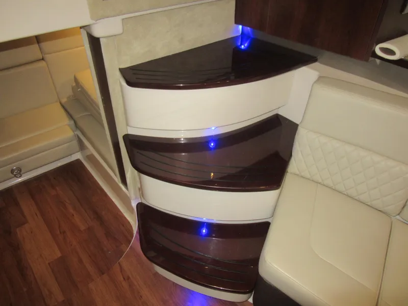 Slide: The Image of Interior of 2017 Chaparral 330 Signature boat with wood flooring and beige seating. - 28