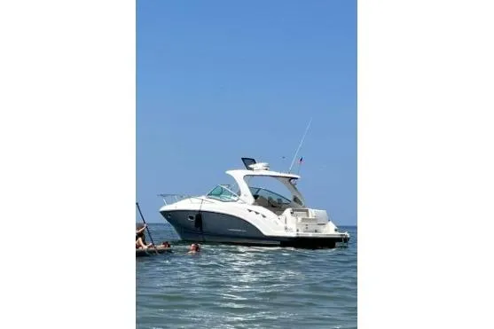 Slide: The Image of 2017 Chaparral 330 Signature boat on calm water under clear blue sky. - 50