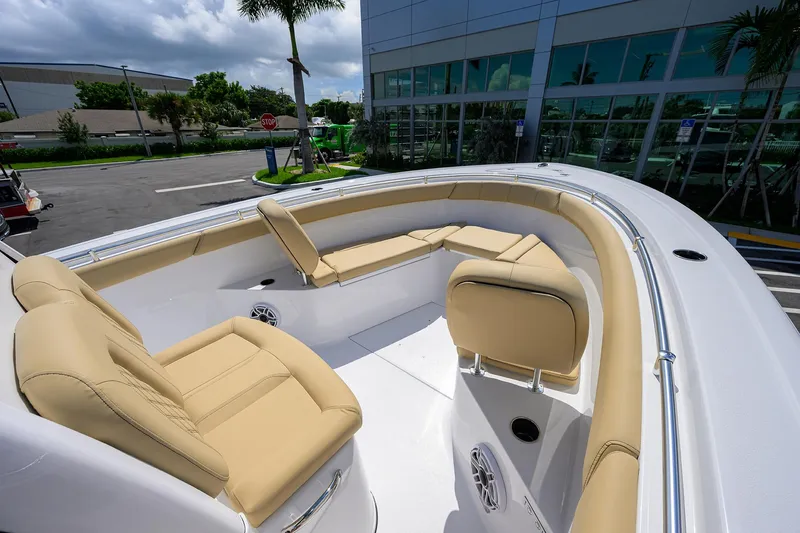 Slide: The Image of 2026 Sportsman Open 302 Center Console boat with beige seating, docked near a modern building. - 10