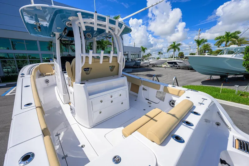 Slide: The Image of 2026 Sportsman Open 302 Center Console boat with beige seating, docked under a blue sky. - 12