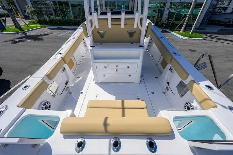 Slide: The Image of 2026 Sportsman Open 302 Center Console boat interior with beige seating and storage compartments. - 16