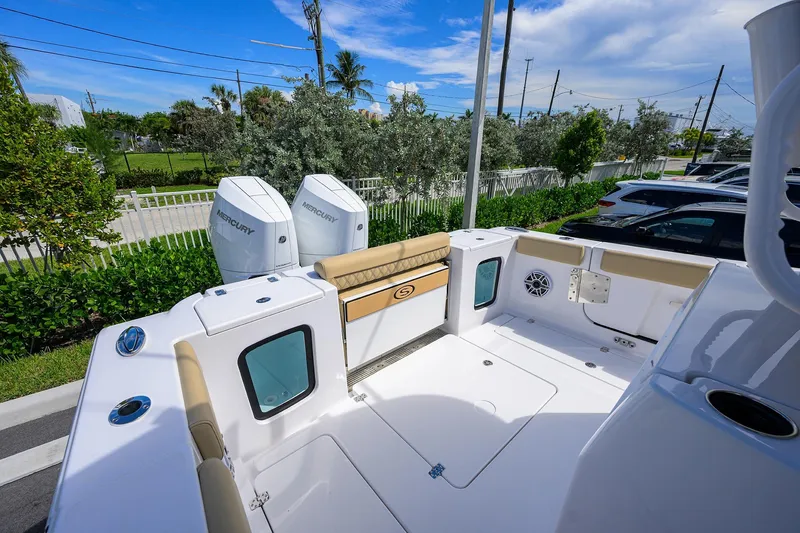 Slide: The Image of 2026 Sportsman Open 302 Center Console boat with dual Mercury engines, parked outdoors. - 17