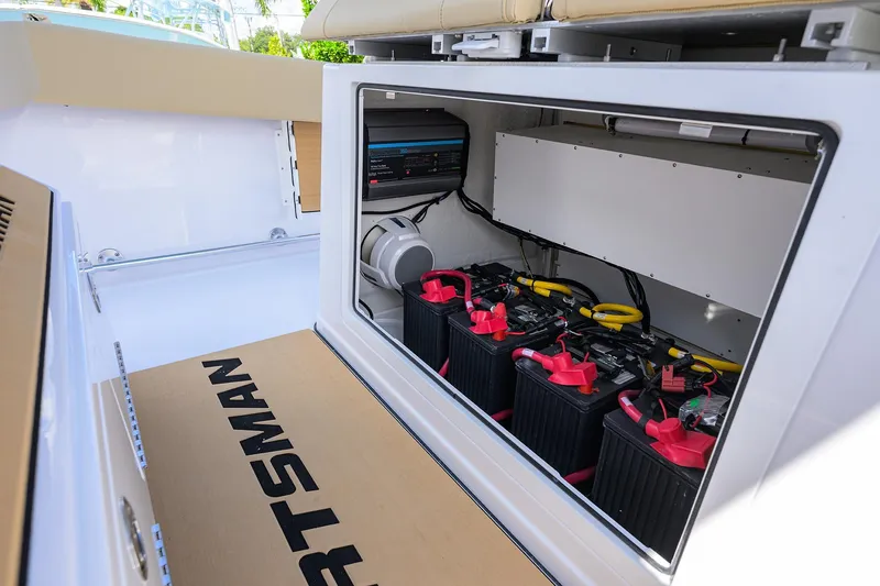 Slide: The Image of 2026 Sportsman Open 302 Center Console boat battery compartment with multiple batteries and wiring. - 30