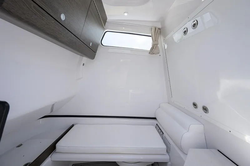 Slide: The Image of 2026 Sportsman Open 302 Center Console cabin interior with sleek white design and storage. - 32