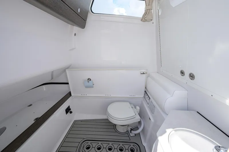Slide: The Image of 2026 Sportsman Open 302 Center Console boat interior with toilet and sink. - 33