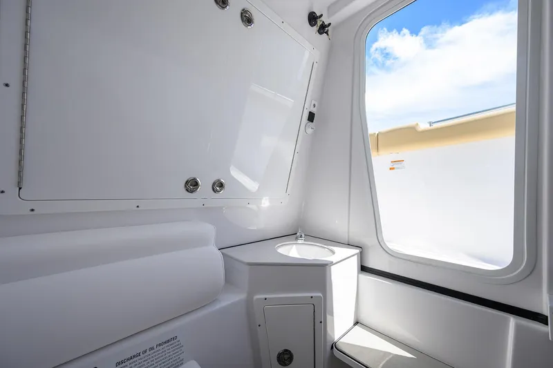 Slide: The Image of Interior of 2026 Sportsman Open 302 Center Console boat, featuring a compact sink and window. - 35