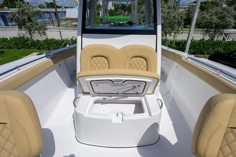 Slide: The Image of 2026 Sportsman Open 302 Center Console boat interior with tan seating and storage compartment. - 6