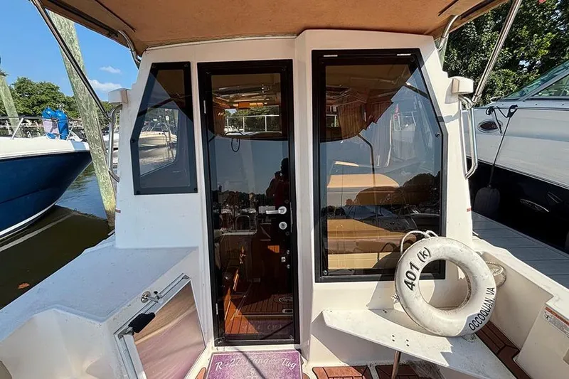 Slide: The Image of 2021 Ranger Tugs R-27 boat stern view with glass doors and life ring. - 11