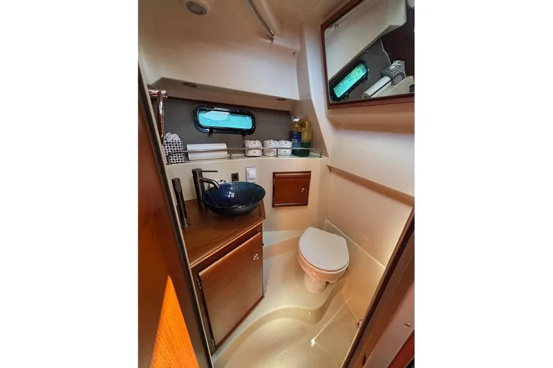 Slide: The Image of 2021 Ranger Tugs R-27 boat bathroom with sink, toilet, and storage cabinets. - 12