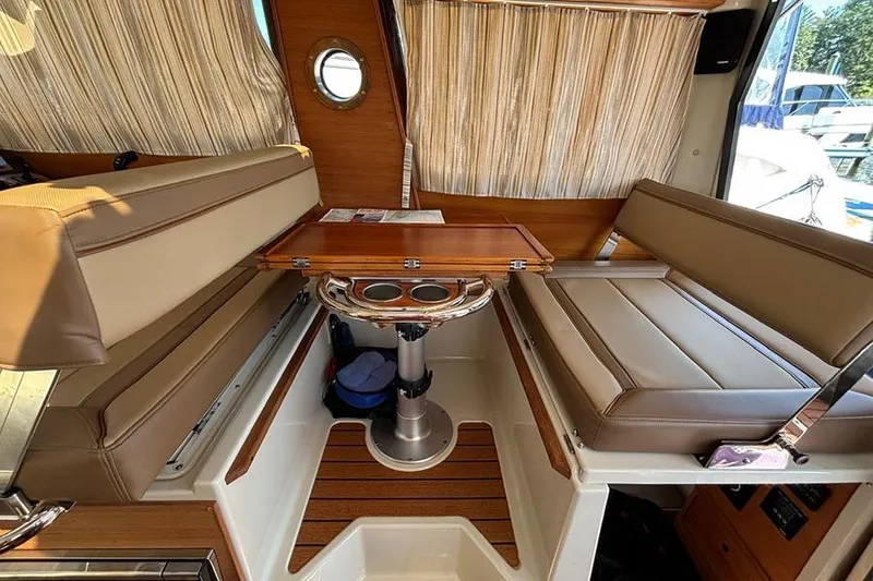 Slide: The Image of Interior of 2021 Ranger Tugs R-27 with seating and wooden table. - 20