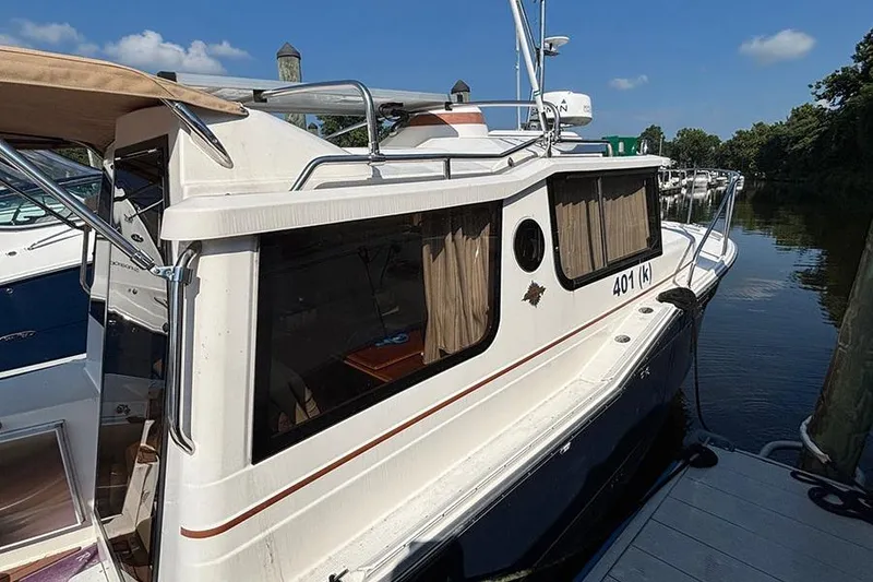 Slide: The Image of 2021 Ranger Tugs R-27 docked, featuring sleek design and spacious cabin windows. - 3