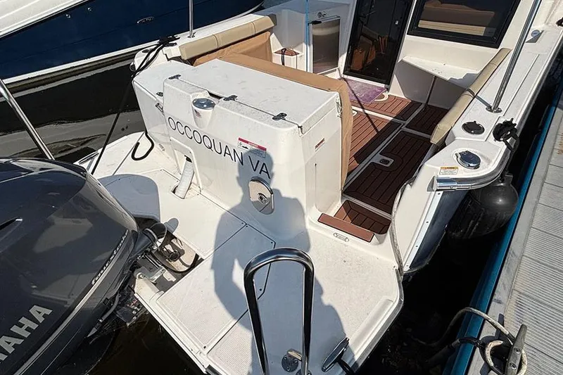 Slide: The Image of 2021 Ranger Tugs R-27 boat docked, featuring spacious deck and Yamaha engine. - 4