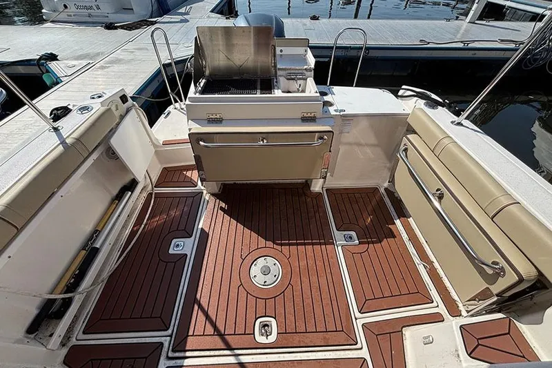 Slide: The Image of 2021 Ranger Tugs R-27 boat deck with seating and grill, docked at marina. - 6