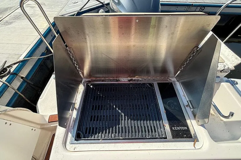 Slide: The Image of Outdoor grill on 2021 Ranger Tugs R-27 boat, featuring Kenyon cooking surface. - 7