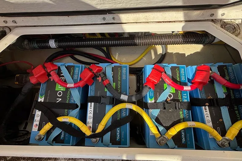 Slide: The Image of Lithium batteries in a 2021 Ranger Tugs R-27 boat, neatly connected with red and yellow cables. - 9