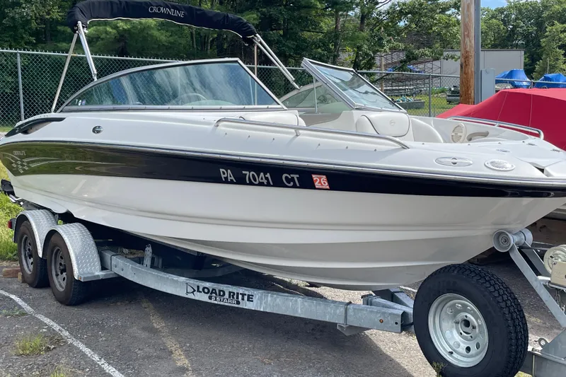 Slide: The Image of 2004 Crownline 216 LS boat on trailer, parked outdoors, with black and white exterior. - 9