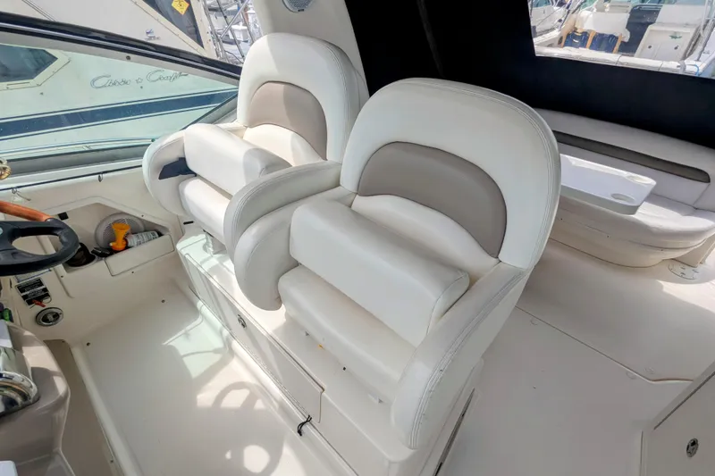 Slide: The Image of 2004 Sea Ray 340 Sundancer cockpit with plush white seating and steering wheel. - 10