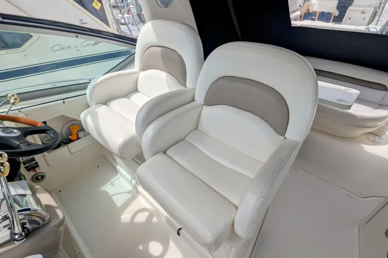 Slide: The Image of 2004 Sea Ray 340 Sundancer cockpit with plush white seating and steering wheel. - 11