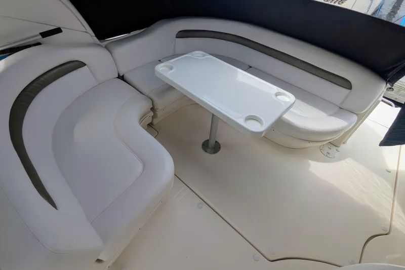 Slide: The Image of 2004 Sea Ray 340 Sundancer interior with white seating and table in the cockpit area. - 13