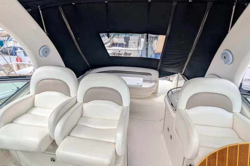 Slide: The Image of Interior of 2004 Sea Ray 340 Sundancer with white seating and black canopy. - 16