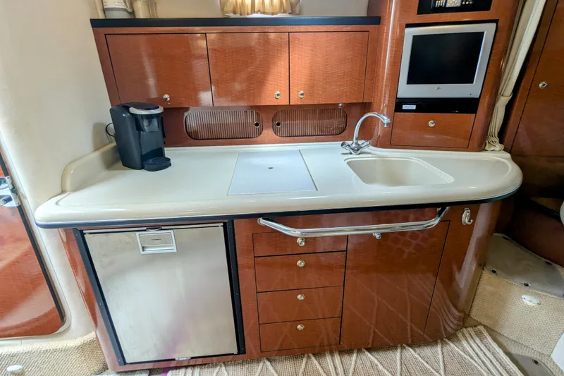 Slide: The Image of 2004 Sea Ray 340 Sundancer galley with sink, cabinets, and coffee maker. - 21