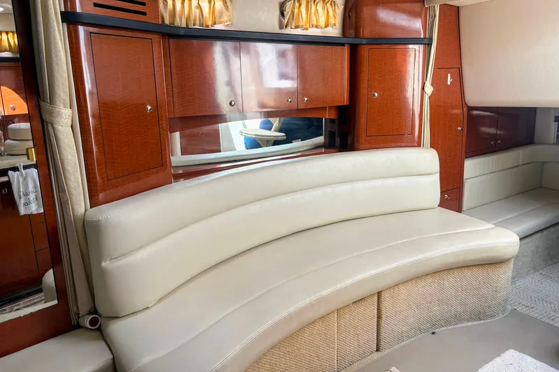 Slide: The Image of Luxurious interior of 2004 Sea Ray 340 Sundancer with curved leather seating and wooden cabinetry. - 23