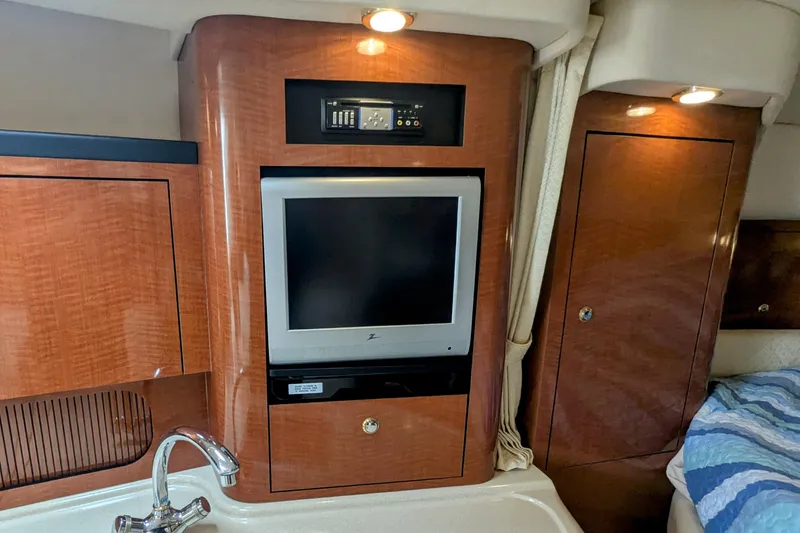 Slide: The Image of 2004 Sea Ray 340 Sundancer interior with wood cabinetry, TV, and sink. - 24