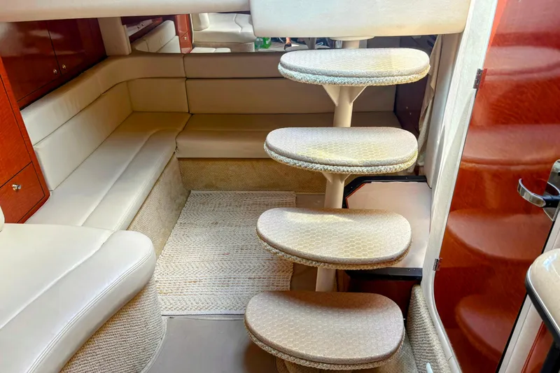 Slide: The Image of Interior of 2004 Sea Ray 340 Sundancer with curved seating and carpeted steps. - 25