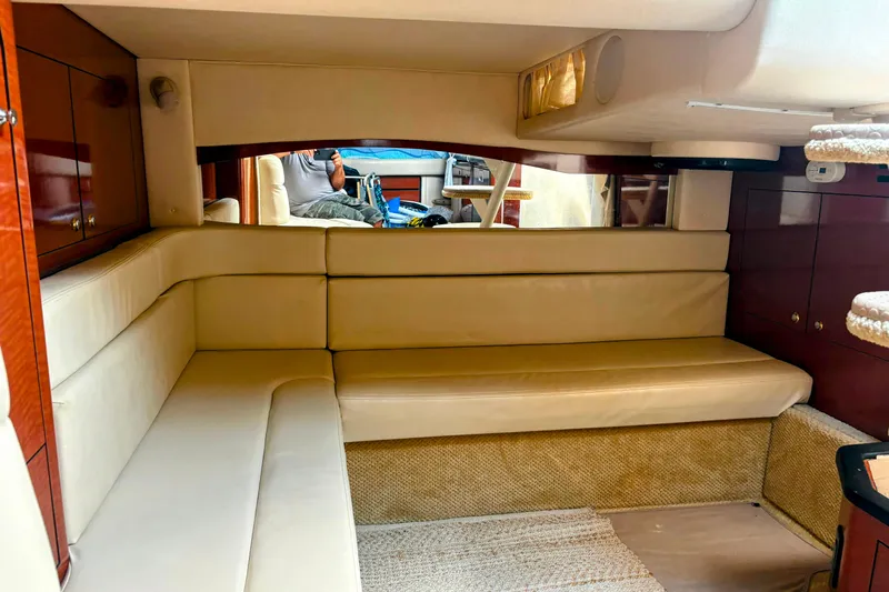 Slide: The Image of Interior of 2004 Sea Ray 340 Sundancer with beige seating and wooden cabinetry. - 27