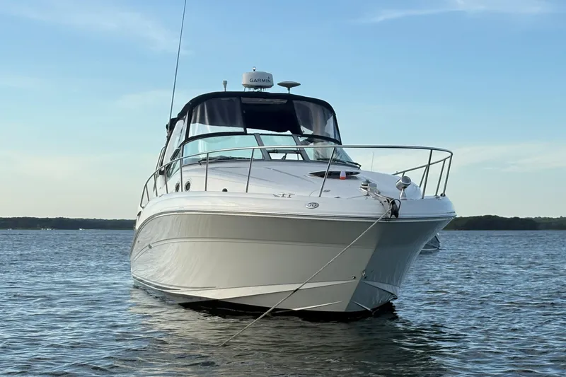 Slide: The Image of 2004 Sea Ray 340 Sundancer boat on calm water under a clear sky. - 3