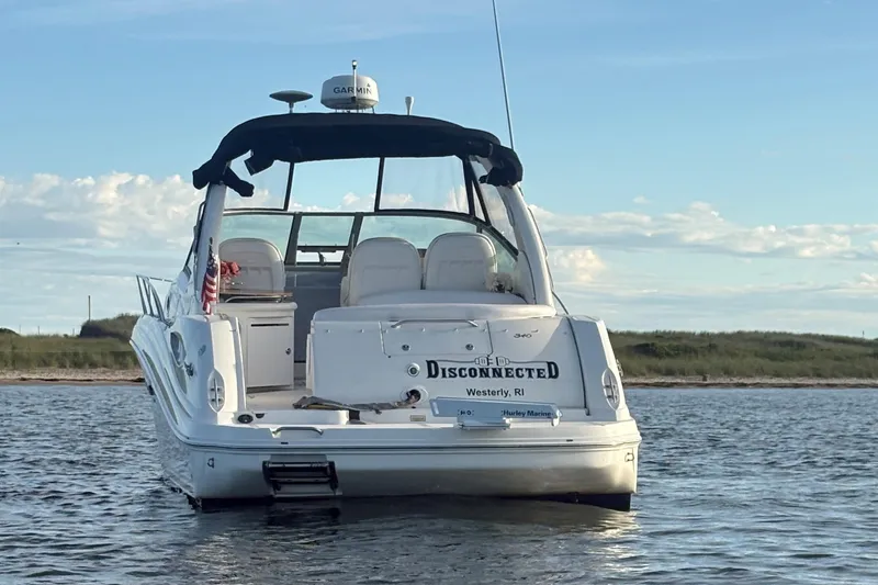 Slide: The Image of 2004 Sea Ray 340 Sundancer boat on water, rear view, clear sky background. - 4