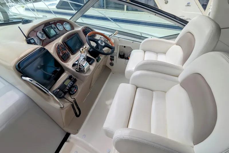 Slide: The Image of 2004 Sea Ray 340 Sundancer helm with dual seats and navigation controls. - 6