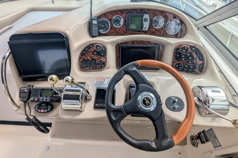 Slide: The Image of 2004 Sea Ray 340 Sundancer helm with steering wheel, controls, and navigation instruments. - 7