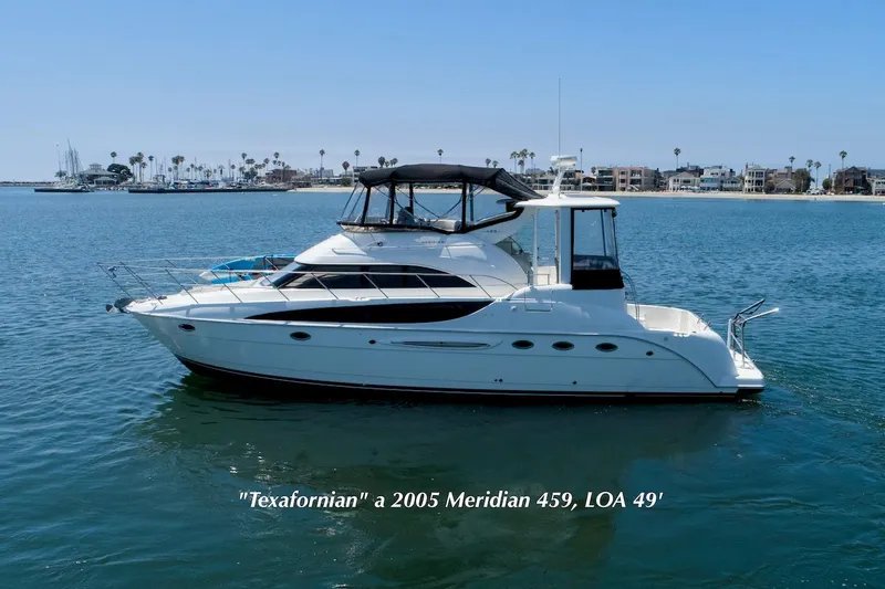 Slide: The Image of 2005 Meridian 459 Aft Cabin Motor Yacht on calm water, coastal background. - 0